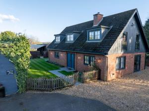 a red brick house with a black roof at Mill Farm in Gamlingay