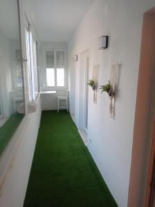 a hallway with a green carpet in a room at Beach Blue Sesimbra in Sesimbra