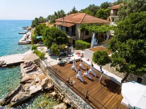 a group of people doing yoga on a wooden deck near the water at MELIES- Seaside Boutique Apartments in Chorto