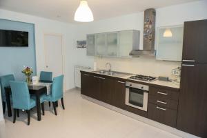 a kitchen and dining room with a table and blue chairs at B&B Fede e Natura in Caposele