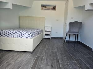 a bedroom with a bed and a chair in it at B&B Fede e Natura in Caposele