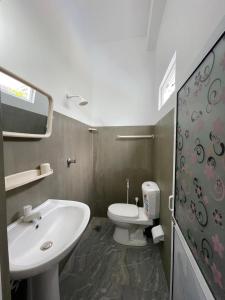 a bathroom with a white toilet and a sink at Emerald Coast Hotel Negombo in Negombo +51 photos