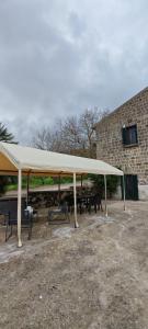 a pavilion with tables and benches under a white canopy at Gli Ulivi del Nonno - Casale immerso nel verde a pochi chilometri dalla Reggia - in Caserta