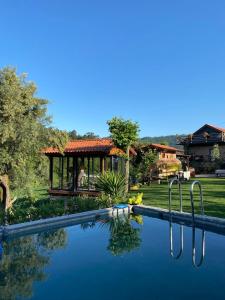 a swimming pool in a yard with a gazebo at Quinta da Eira do Prado in Carvalho