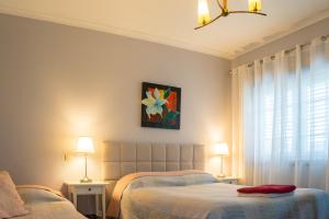 a bedroom with two beds and a painting on the wall at Arouca Passadiços Alojamentos & Jacuzzi - SPA in Arouca +39 photos