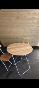 a wooden table and two chairs next to a wall at Aparan HOUSE in Aparan