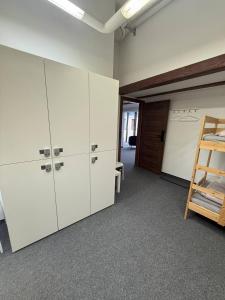 an office room with white cabinets and a ladder at GIRLSTEL Wrocław - Girls ONLY Space in Wrocław