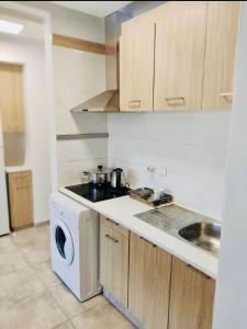 a kitchen with a washing machine and a sink at Jane 202 cosy 1 bedroom in Larnaca
