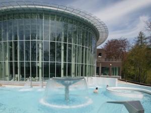 a fountain in a pool in front of a building at Well Coom in Goé