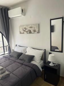 a bedroom with a bed and a mirror and a window at Helios in Ioannina