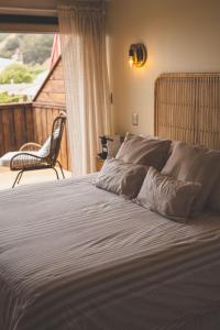 a bedroom with a bed with a chair and a window at Hotel & Boulevard Pacífico in Matanzas