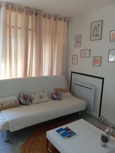 a living room with a white couch and a table at Monplaisir in Fréjus +14 photos