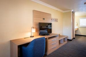a hotel room with a desk with a television and a room at Cayucos Beach Inn in Cayucos