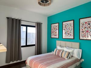 a bedroom with a bed with blue walls and a window at Loteria Mexicana in Senecú