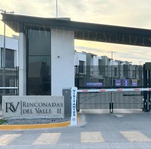 a building with a sign in front of a gate at Loteria Mexicana in Senecú