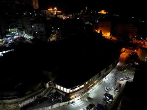 a city at night with cars parked in a parking lot at House Leon in Krujë