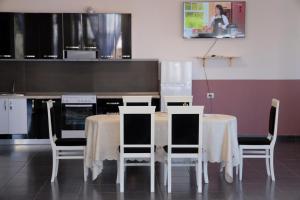 a kitchen with a table with four chairs and a counter at House Leon in Krujë
