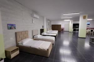 a room with several beds lined up against a wall at House Leon in Krujë