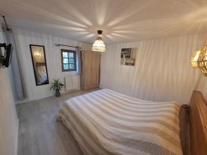 a bedroom with a large bed in a room at La Champêtre in Beaumesnil