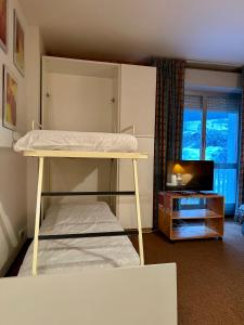 a bedroom with a bunk bed and a television at Il rifugio di Pietro in Sella della Turra