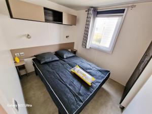 a bedroom with a bed with a yellow object on it at Valras Jasmin 68 in Sérignan