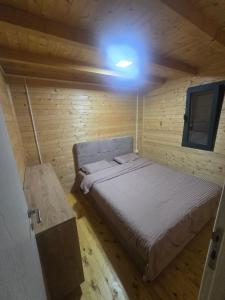 a small bedroom with a bed in a wooden cabin at Sojenica Tamara in Ulcinj