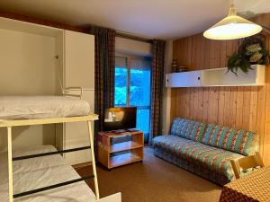 a bedroom with a bunk bed and a couch at Il rifugio di Pietro in Sella della Turra