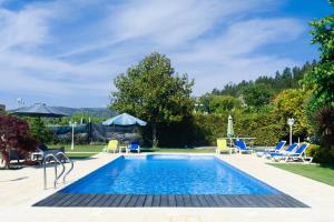 a swimming pool in a backyard with chairs and a table at Arouca Passadiços Alojamentos & Jacuzzi - SPA in Arouca