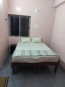 a small bedroom with a bed with at Swarna Lodge in Badami +6 photos