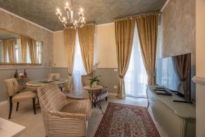a living room with a television and a dining room at Corte Realdi Suites Arena Verona in Verona