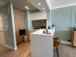 a kitchen with a white island in a room at Sand & Sea - Adults Only in Middelkerke
