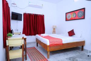 a bedroom with a bed and a red curtain at Garden bay in Pondicherry