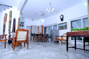 a living room with a piano and chairs and a table at Garden bay in Pondicherry