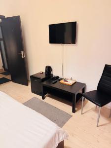 a room with a bed and a table and a television at Infinit Otopeni in Otopeni