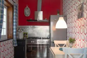 a kitchen with a stainless steel stove and red walls at Arouca Passadiços Alojamentos & Jacuzzi - SPA in Arouca