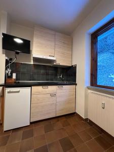 a kitchen with wooden cabinets and a window at Il mini rifugio di Pietro in Miroglio +7 photos