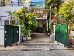 a courtyard with green doors and stairs with plants at Garden bay in Pondicherry