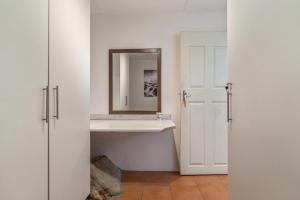 a bathroom with a mirror on a shelf and a door at Seaview in Hout Bay +10 photos