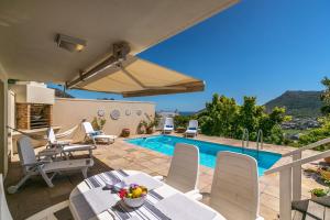 a patio with a table and chairs and a swimming pool at Seaview in Hout Bay