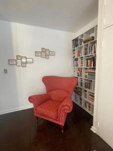 a red chair in a room with a book shelf at The Wild Side in Sandton +8 photos