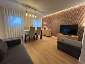 a living room with a table and a couch and a television at Casa da Vila do Rock in Paredes de Coura