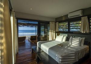 a bedroom with a bed with a view of the ocean at 99 Surf Lodge in El Limón +36 photos