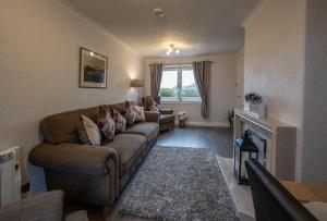 a living room with a couch and a fireplace at Marys view in Fort William