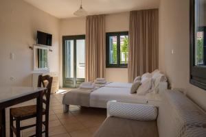 a bedroom with a bed and a couch and a table at So Nice Hotel in Marathokampos