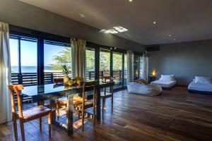 a dining room with a table and chairs and a living room at 99 Surf Lodge in El Limón