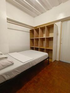 a bedroom with a white bed and shelves at Metro Capsule Rental in Manila