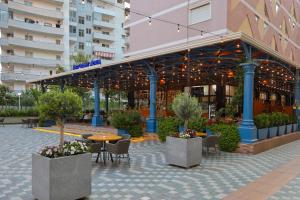 a patio with a table and chairs and a building at Hotel Adria in Shëngjin