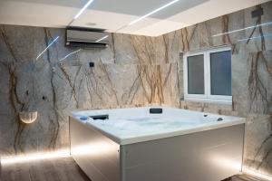 a bathroom with a bath tub and a window at Arouca Passadiços Alojamento & Jacuzzi - SPA in Arouca +24 photos