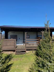 a house with a porch with two wooden benches at Kemping Pod Topolami in Górkło