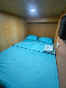 a bed in a small room with blue sheets at Metro Capsule Rental in Manila +18 photos